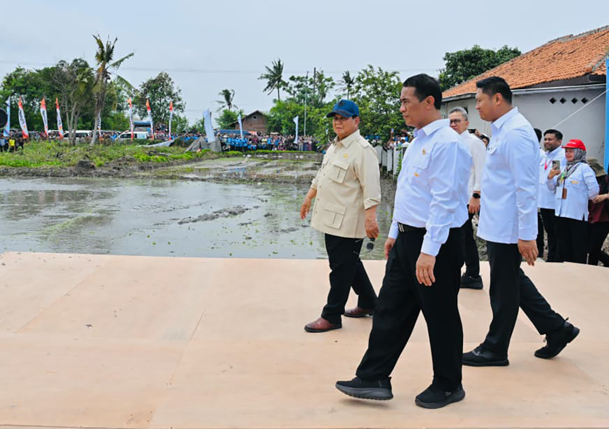 Presiden Prabowo Subianto (tengah) didampingi Menteri Koordinator Bidang Pangan Zulkifli Hasan (kedua kanan) dan Menteri Pertanian Amran Sulaiman (kanan) menumbukkan alu pada lesung dalam acara panen raya dan pengumuman swasembada pangan nasional 2025 di Cilebar, Karawang, Jawa Barat, Rabu (7/1/2026). (Biropers)