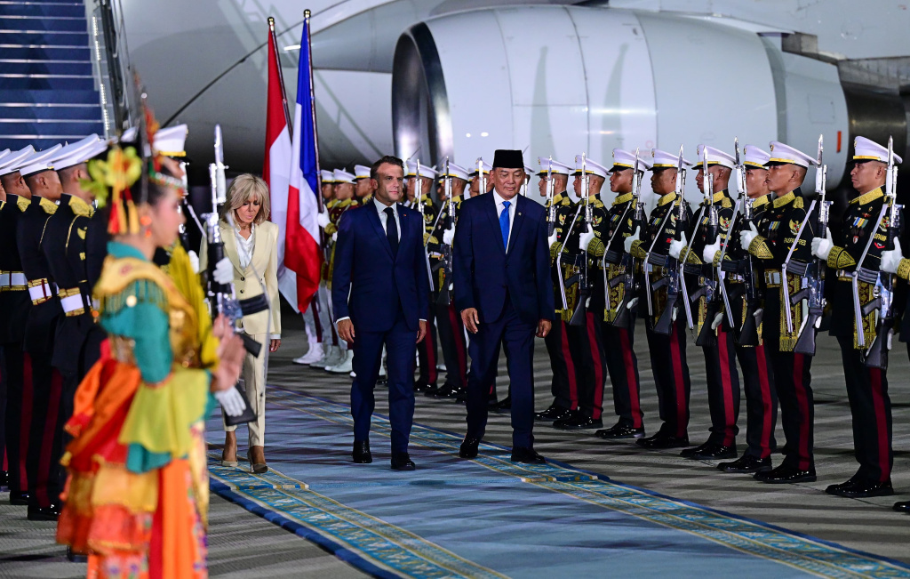 Presiden Prancis tiba di Indonesia Presiden Prancis Emmanuel Macron (kanan) bersama istri Brigitte Macron (kiri) menuruni tangga pesawat saat tiba di Pangkalan Udara TNI AU Halim Perdanakusuma, Jakarta, Selasa (27/5/2025). (Beritanasional.com/Oke Atmaja)
