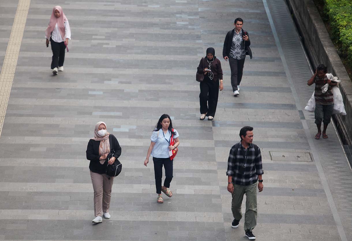 Sejumlah pekerja berjalan kaki di Trotoar jalan Sudirman-Thamrin, Kawasan Bendungan Hilir, Jakarta, Kamis (14/10/2025).(Beritanasional.com/Oke Atmaja)