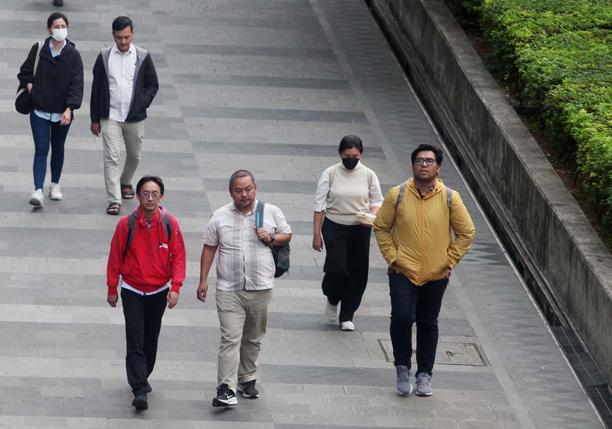 Sejumlah pekerja berjalan kaki di Trotoar jalan Sudirman-Thamrin, Kawasan Bendungan Hilir, Jakarta, Kamis (14/10/2025).(Beritanasional.com/Oke Atmaja)