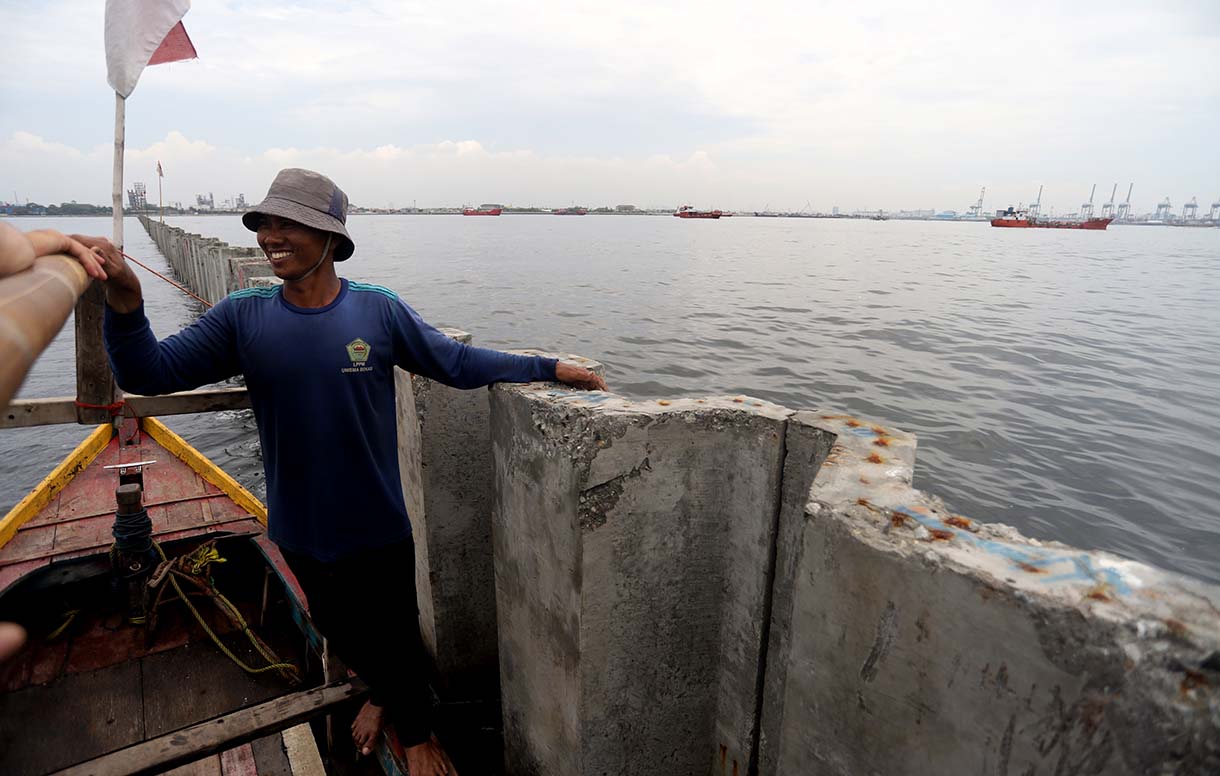 Nelayan berada di atas proyek tanggul beton di perairan Cilincing, Jakarta, Minggu(14/9/2025).  (Beritanasional.com/Oke Atmaja)