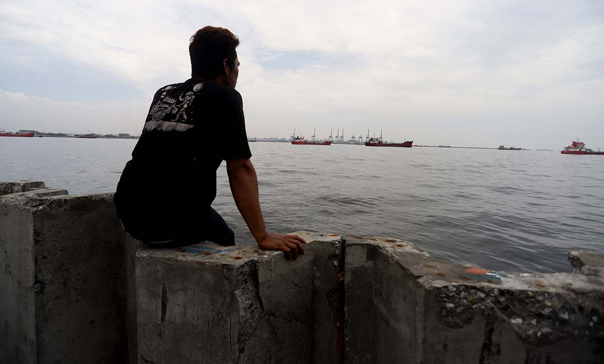 Nelayan berada di atas proyek tanggul beton di perairan Cilincing, Jakarta, Minggu(14/9/2025).  (Beritanasional.com/Oke Atmaja)