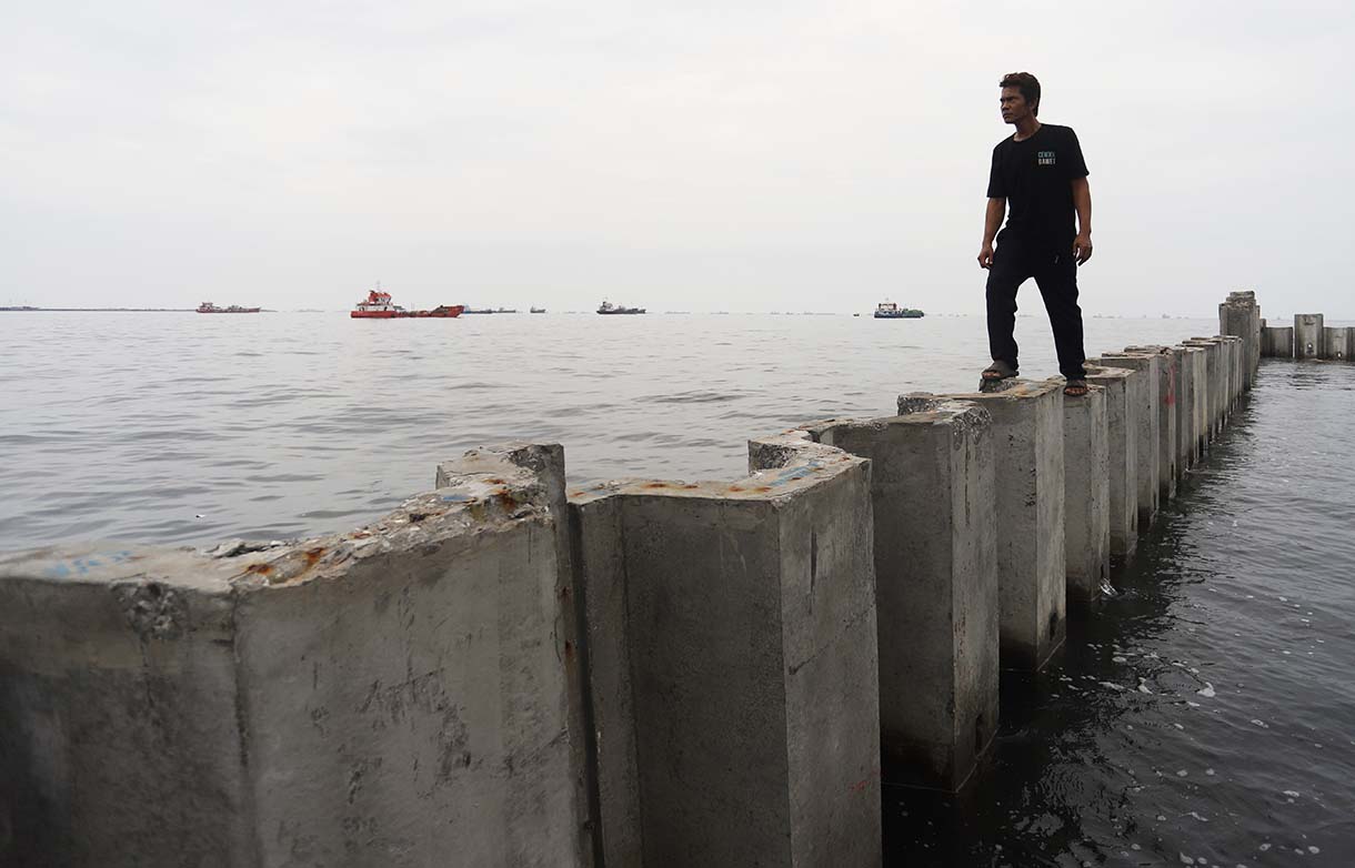 Nelayan berada di atas proyek tanggul beton di perairan Cilincing, Jakarta, Minggu(14/9/2025).  (Beritanasional.com/Oke Atmaja)