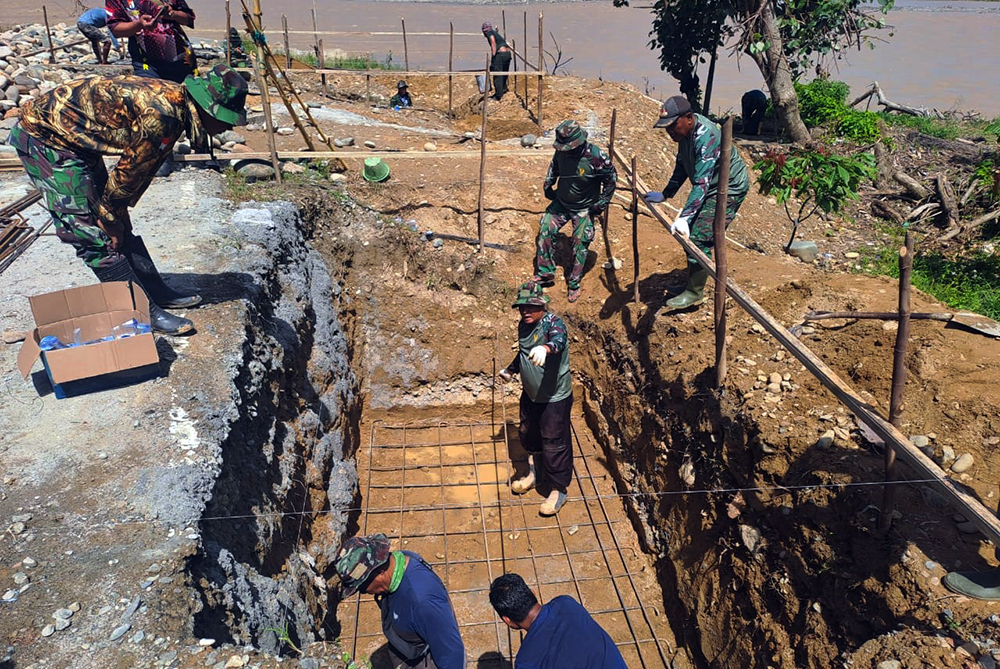 Babinsa Koramil 0108-03/Badar dan personel Posramil Darul Hasanah Kodim 0108/Aceh Tenggara bersama warga membangun jembatan gantung perintis di Desa Kumbang Jaya, Kecamatan Badar, Kabupaten Aceh Tenggara.   (BeritaNasional/Elvis/HO Dispenad)