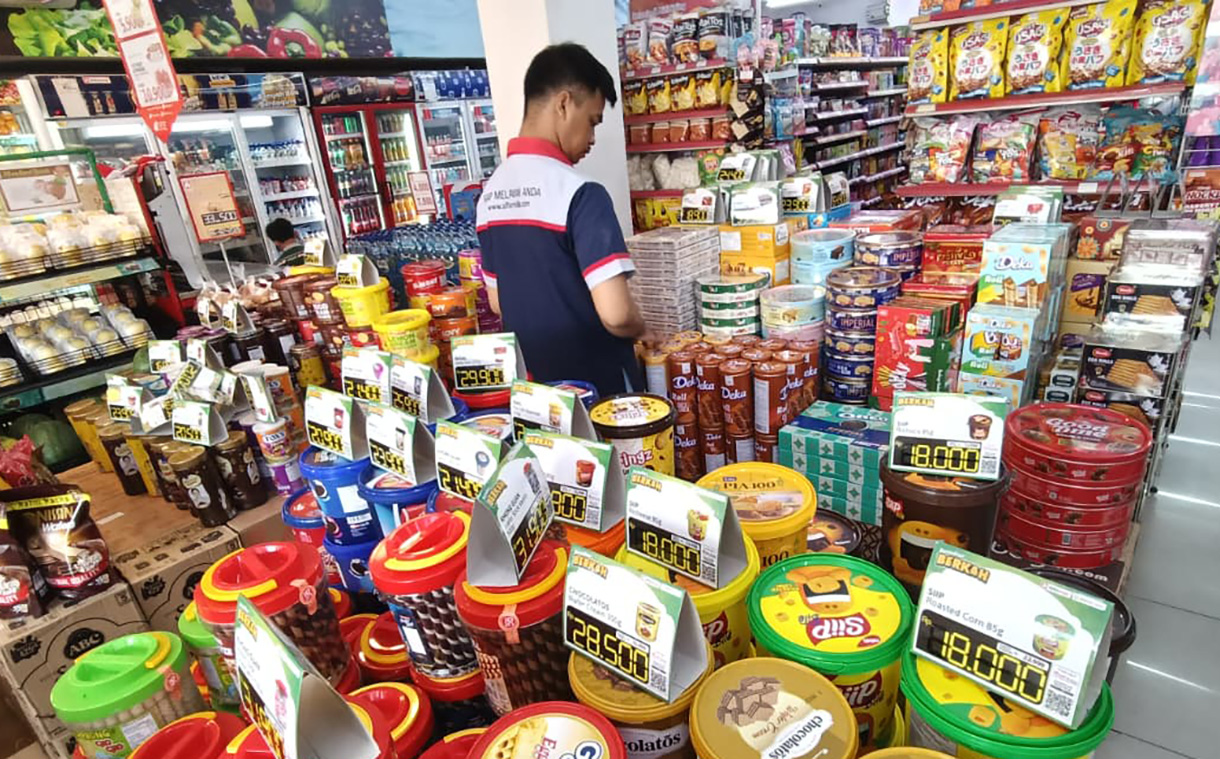 Karyawan supermarket merapikan produk makanan dan minuman di Jakarta, Minggu (1/3/2026).(Beritanasional.com/Oke Atmaja)