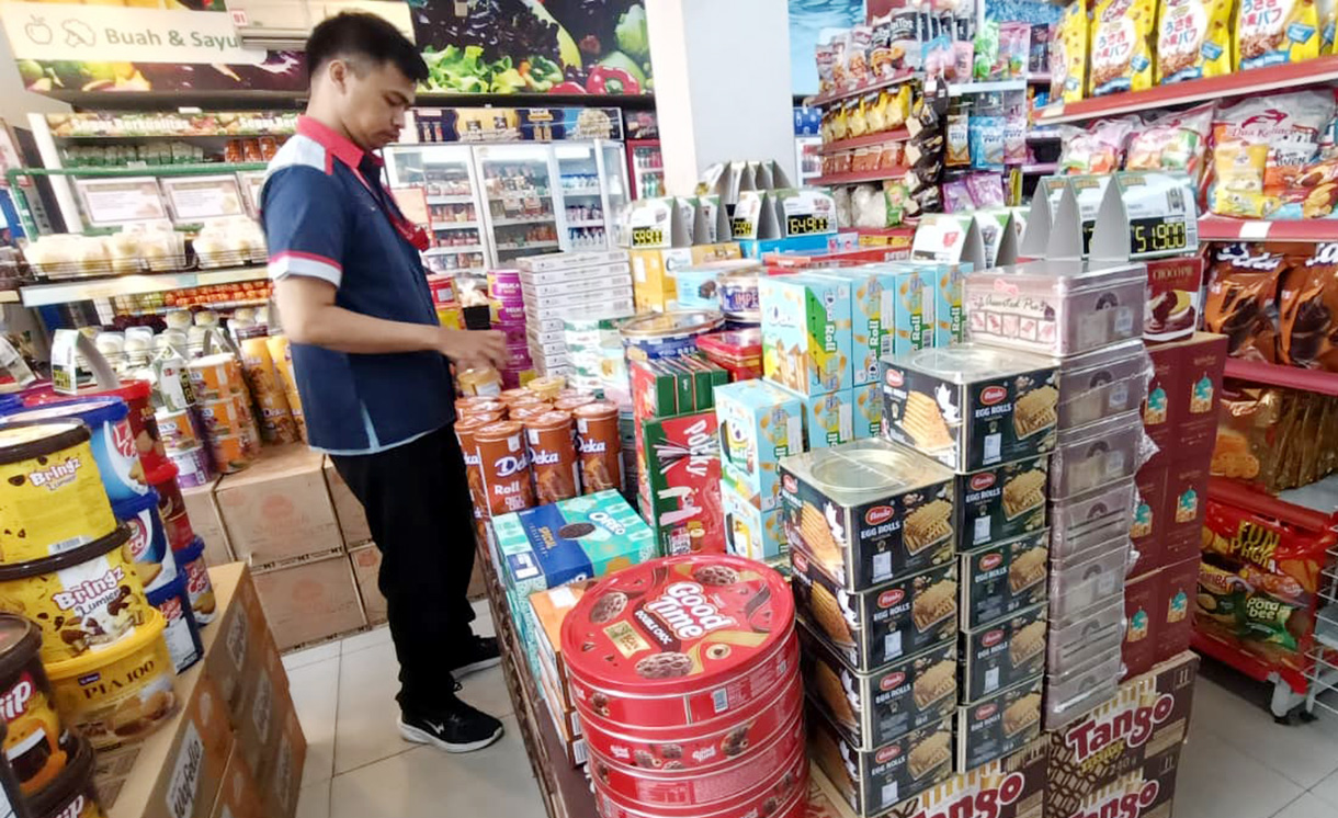 Karyawan supermarket merapikan produk makanan dan minuman di Jakarta, Minggu (1/3/2026).(Beritanasional.com/Oke Atmaja)