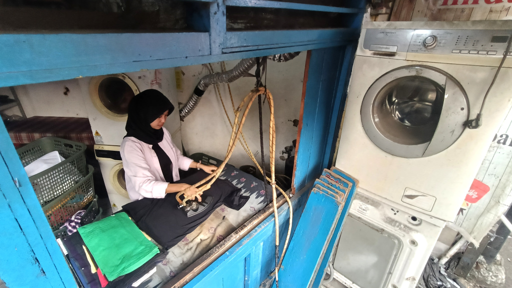 Realisasi Penyaluran KUR 2025 Pekerja meneriska pakaian di salah satu usaha cuci pakaian di Menteng Jaya, Jakarta, Senin (01/09/2025). (Beritanasional.com/Oke Atmaja)