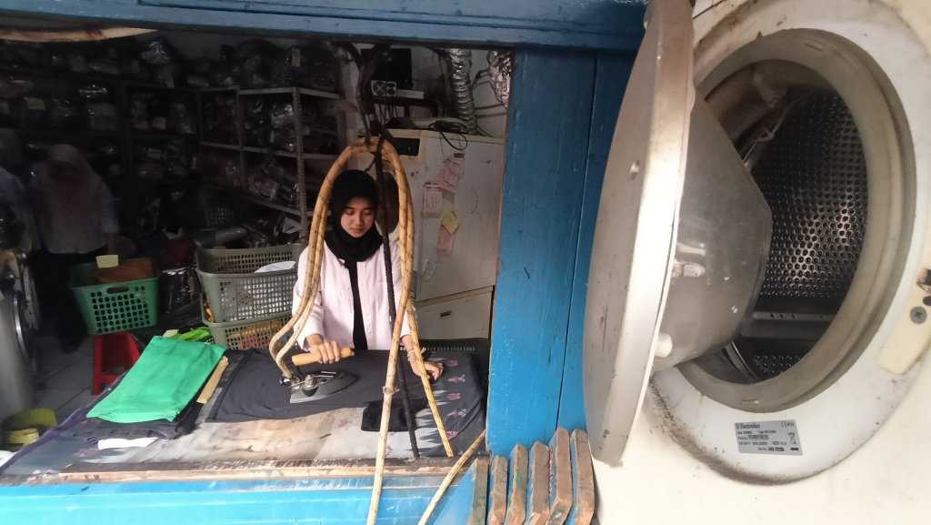 Realisasi Penyaluran KUR 2025 Pekerja meneriska pakaian di salah satu usaha cuci pakaian di Menteng Jaya, Jakarta, Senin (01/09/2025). (Beritanasional.com/Oke Atmaja)