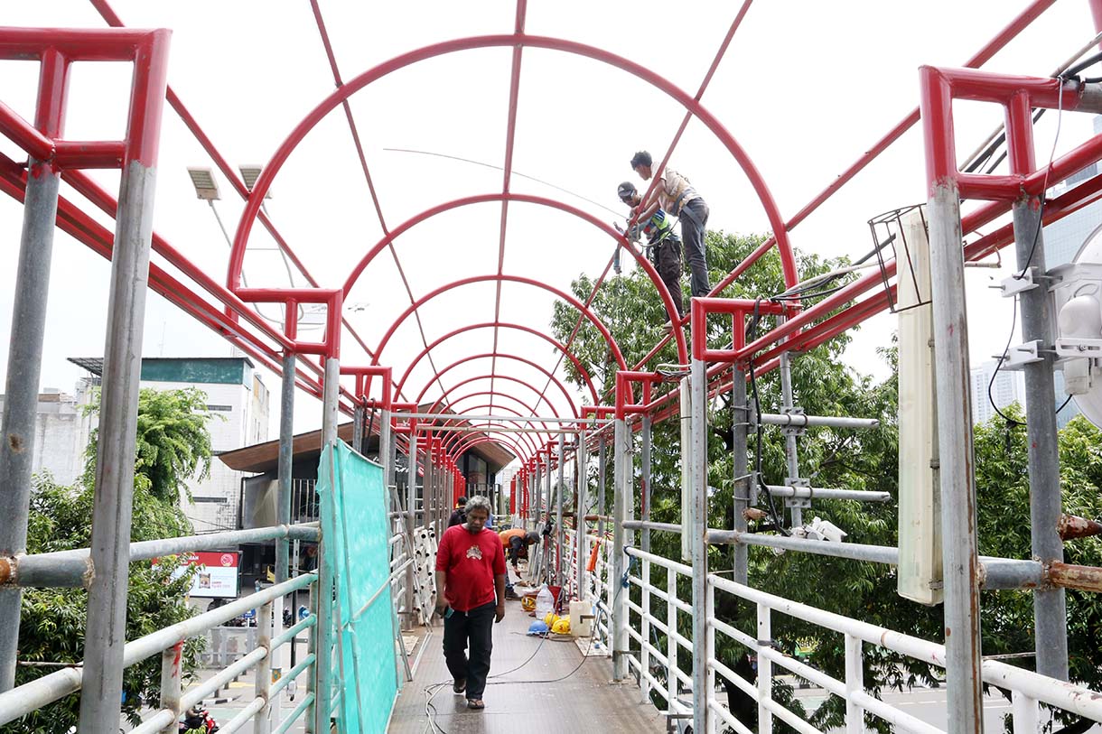 Pekerja menyelesaikan perbaikan Jembatan Penyeberangan Orang (JPO) Salemba di Jalan Salemba Raya, Jakarta, Kamis (11/9/2025).  (Beritanasional.com/Oke Atmaja)