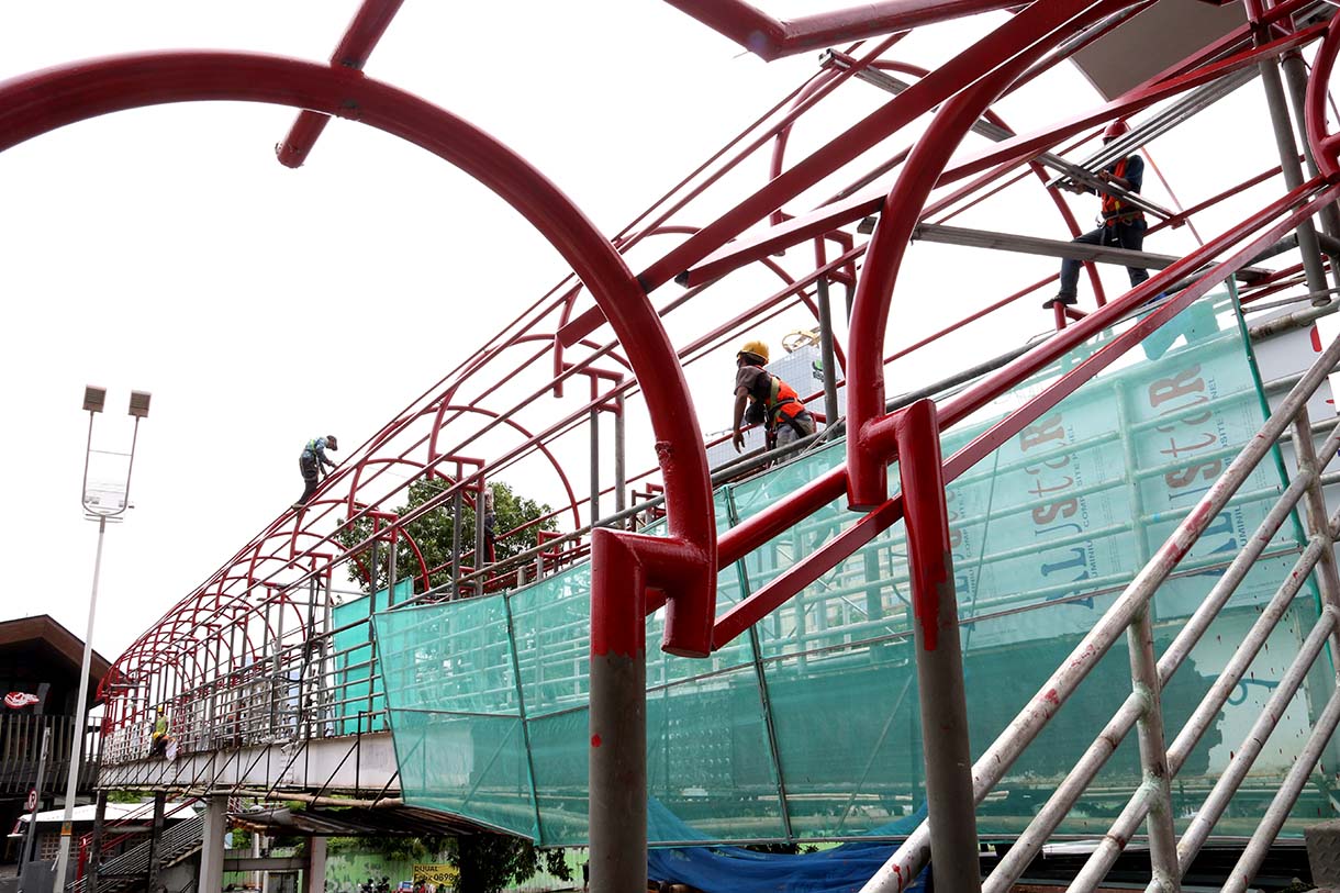 Pekerja menyelesaikan perbaikan Jembatan Penyeberangan Orang (JPO) Salemba di Jalan Salemba Raya, Jakarta, Kamis (11/9/2025).  (Beritanasional.com/Oke Atmaja)