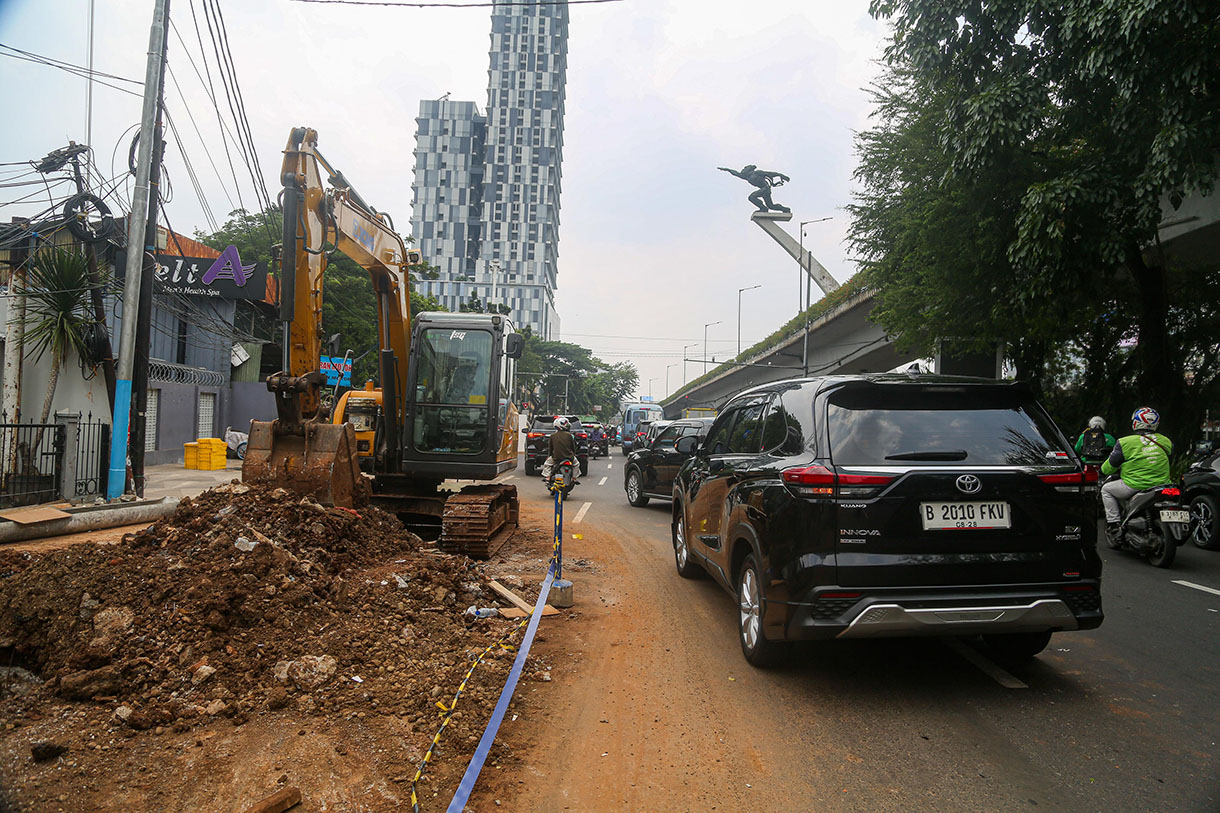 Pekerja menggunakan alat berat menyelesaikan perbaikan trotoar di Jalan Prof. DR. Soepomo, Jakarta, Rabu (9/10/2024).(BeritaNasional.com/Oke Atmaja)