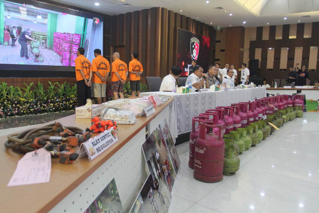 Rilis Kasus Penyuntikan Gas LPG Bersubsidi Petugas menata barang bukti tabung gas LPG 3 kilogram bersubsidi pada keterangan pers terkait kasus pengoplosan atau penyuntikan gas LPG bersubsidi di Bareskrim Polri, Jakarta, Senin (5/5/2025). (Beritanasional.com/Oke Atmaja)