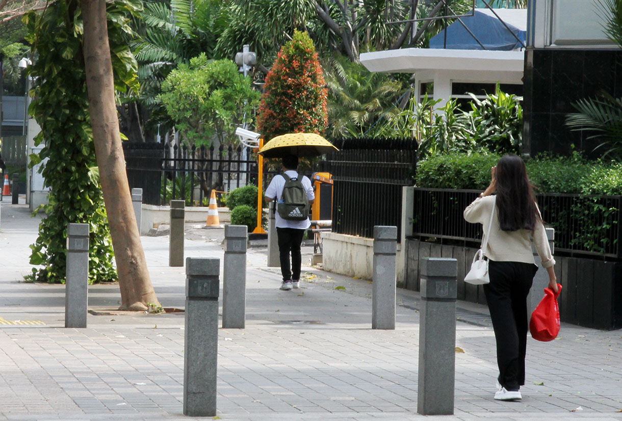 Pejalan kaki berjalan di trotoar Jalan Sudirman, Jakarta, Minggu(29/9/2024). (BeritaNasional.com/Oke Atmaja)