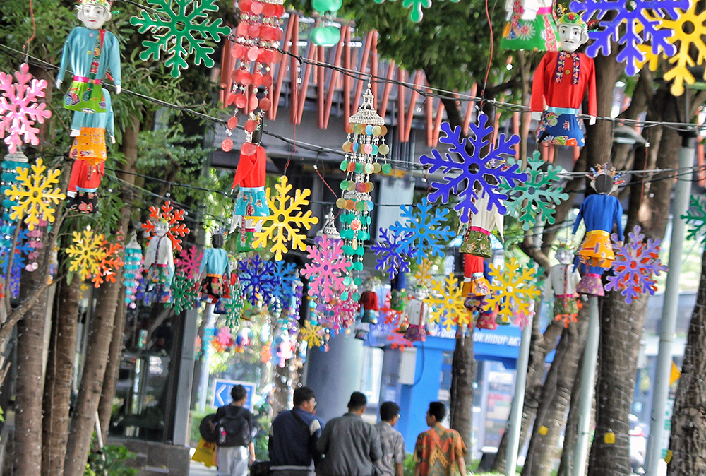 Warga melintas jalan di kawasan Jakarta Pusat yang dipenuhi hiasan tematk budaya Betawi sambut HUT Jakarta 499. (BeritaNasional/Elvis Sendouw)