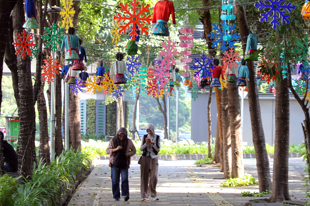 Warga melintas jalan di kawasan Jakarta Pusat yang dipenuhi hiasan tematk budaya Betawi sambut HUT Jakarta 499. (BeritaNasional/Elvis Sendouw)