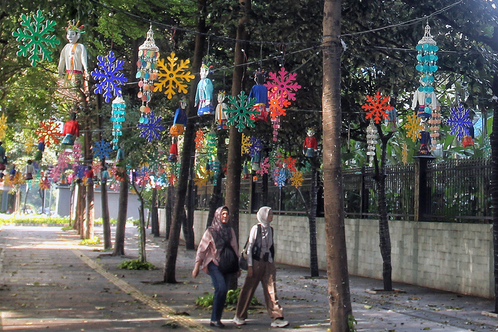 Warga melintas jalan di kawasan Jakarta Pusat yang dipenuhi hiasan tematk budaya Betawi sambut HUT Jakarta 499. (BeritaNasional/Elvis Sendouw)