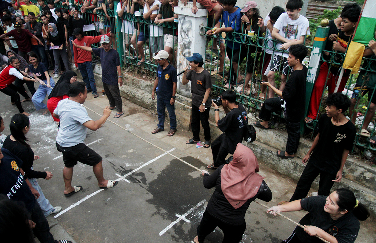 Dua orang bocah mengikuti lomba memasukan air kedalam botol dengan mata tertutup di Jalan Menteng Jaya, Jakarta, Sabtu (09/08/2025). (Beritanasional.com/Oke Atmaja)