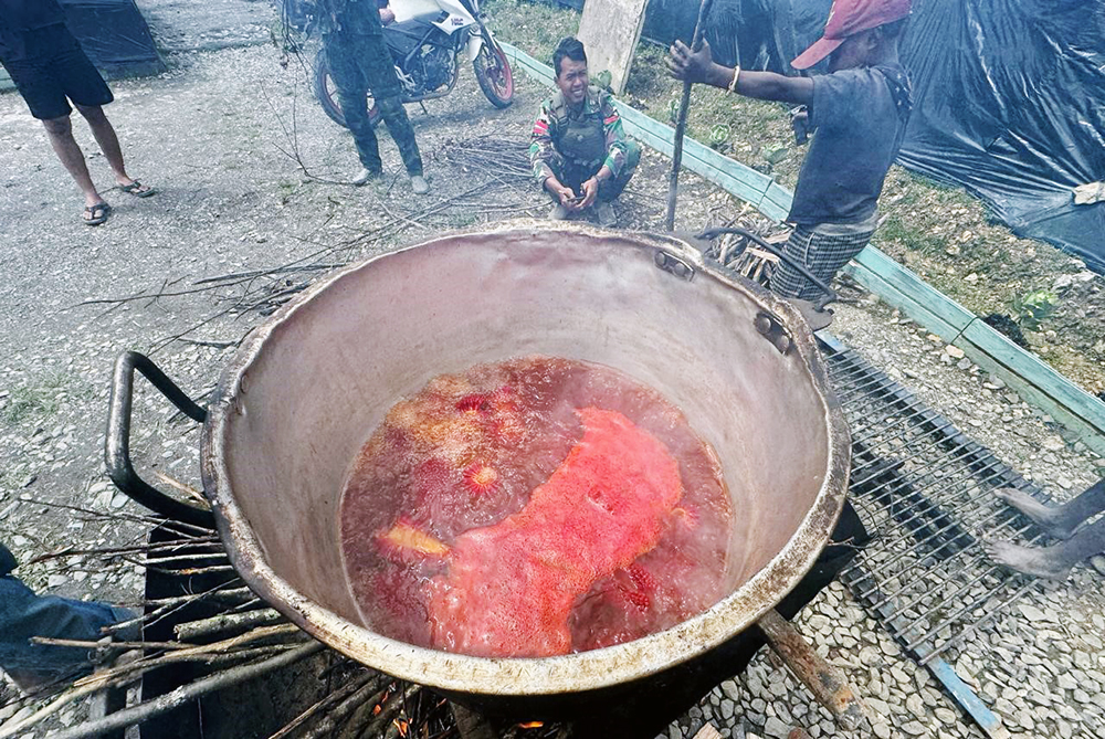 Prajurit Satgas Yonif 509 Kostrad bersama anak-anak Papua berbagi bahagia saat mencoba makan buah merah Papua. (BeritaNasional/HO/Elvis Sendouw)