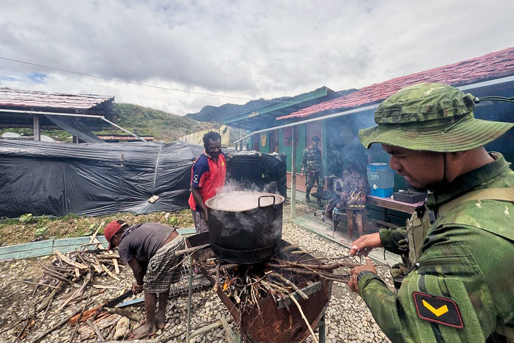 Prajurit Satgas Yonif 509 Kostrad bersama anak-anak Papua berbagi bahagia saat mencoba makan buah merah Papua. (BeritaNasional/HO/Elvis Sendouw)