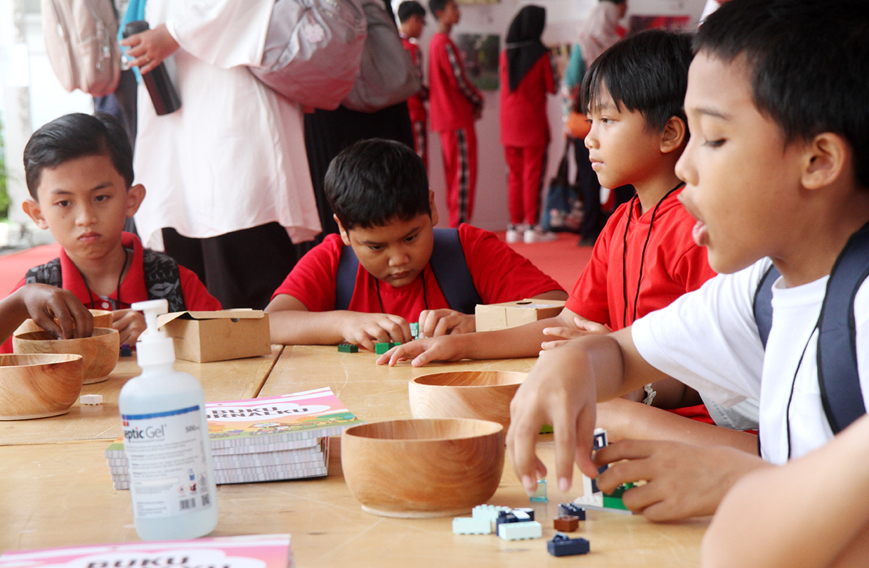 Guru penyandang disabilitas tunarungu menjelaskan foto kepada anak disabilitas tunarungu dalam rangkaian kegiatan "Satu Hari Bermain Bersama Anak" di Gedung Kemanterian Pembangunan Manusia dan Kebudayaan (PMK), Jakarta, Sabtu (10/8/2024).(BeritaNasional.com/Oke Atmaja)