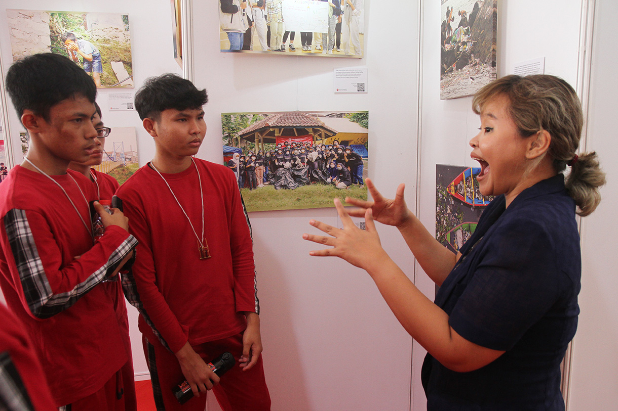 Guru penyandang disabilitas tunarungu menjelaskan foto kepada anak disabilitas tunarungu dalam rangkaian kegiatan "Satu Hari Bermain Bersama Anak" di Gedung Kemanterian Pembangunan Manusia dan Kebudayaan (PMK), Jakarta, Sabtu (10/8/2024).(BeritaNasional.com/Oke Atmaja)