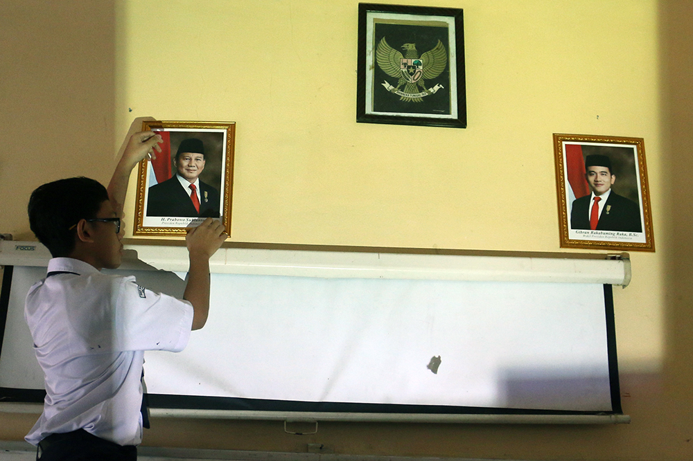 Pemasangan foto Presiden Prabowo Subianto dan Wakil Presiden Gibran Rakabuming Raka di sekolah. (BeritaNasional/Elvis Sendouw)