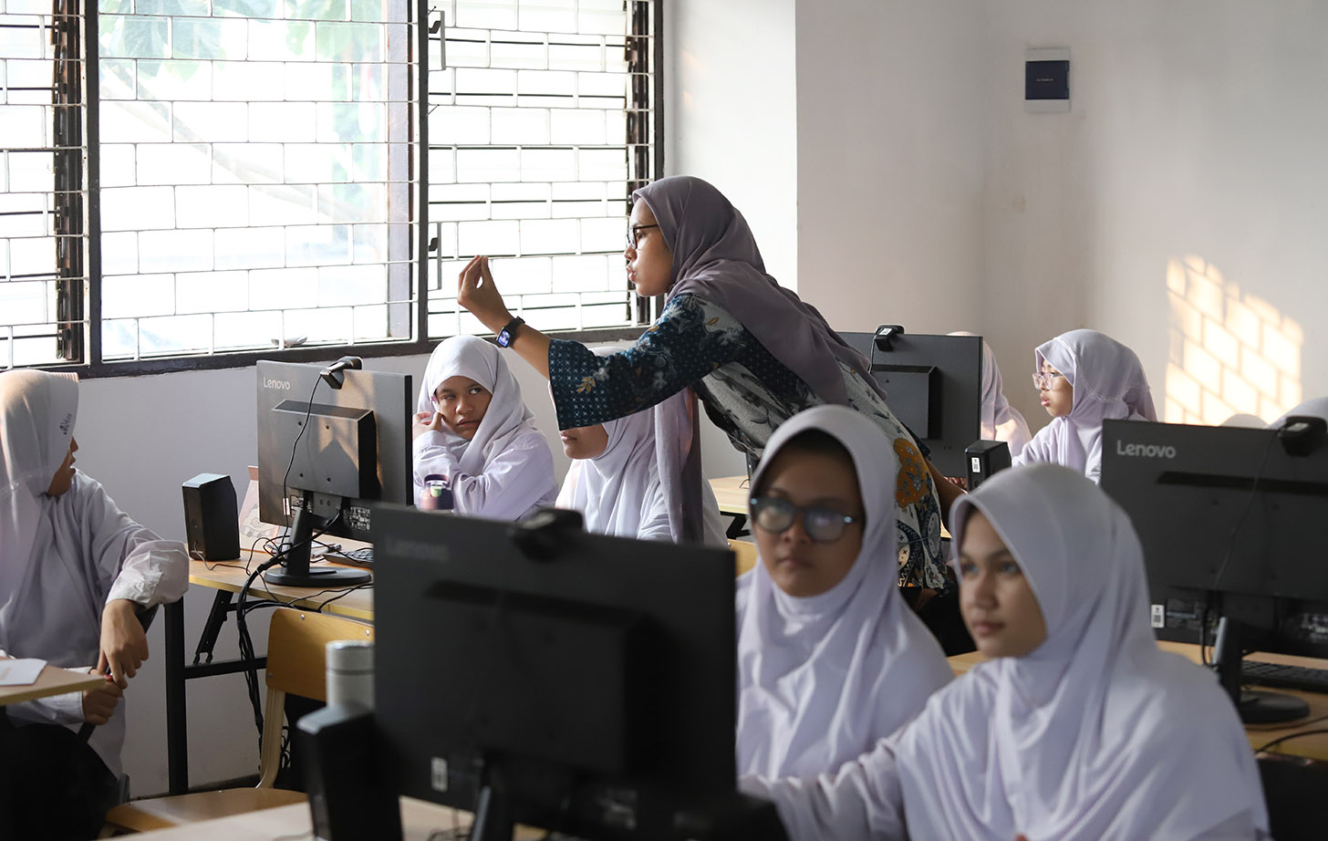 Guru memberikan materi menggunakan bahasa isyarat kepada santri disabilitas pendengaran saat belajar desain komputer di Pondok Pesantren Tahfidz Difabel KH Ahmad Lutfi Fathullah, Jakarta, Senin (3/6/2024).(BeritaNasional.Com/Oke Atmaja)