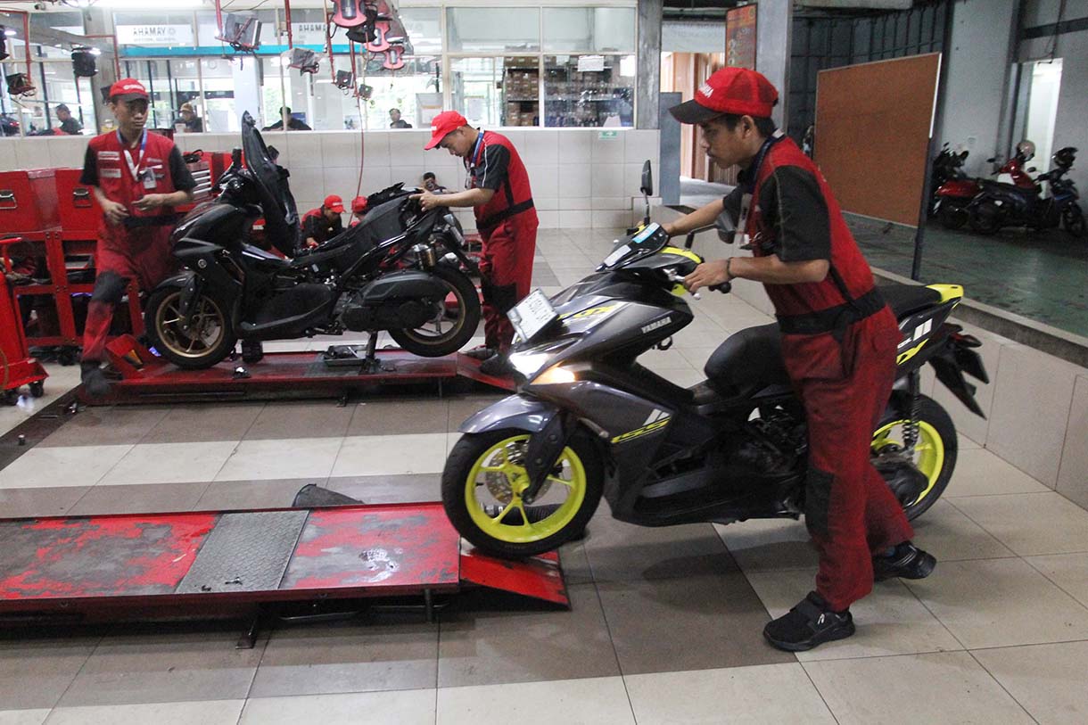 Mekanik memperbaiki motor di bengkel motor Yamaha, Bintaro, Jakarta, Rabu (19/3/2025).  (Beritanasional.com/Oke Atmaja)