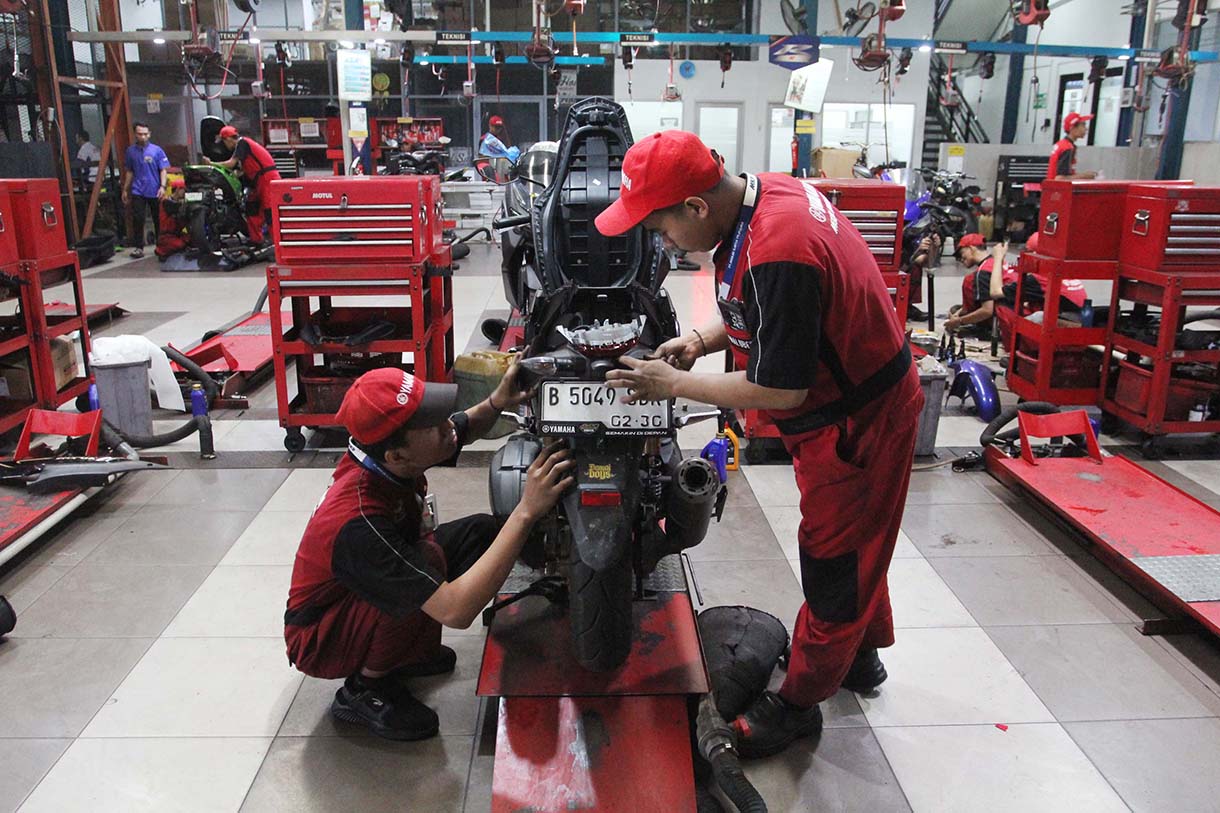 Mekanik memperbaiki motor di bengkel motor Yamaha, Bintaro, Jakarta, Rabu (19/3/2025).  (Beritanasional.com/Oke Atmaja)