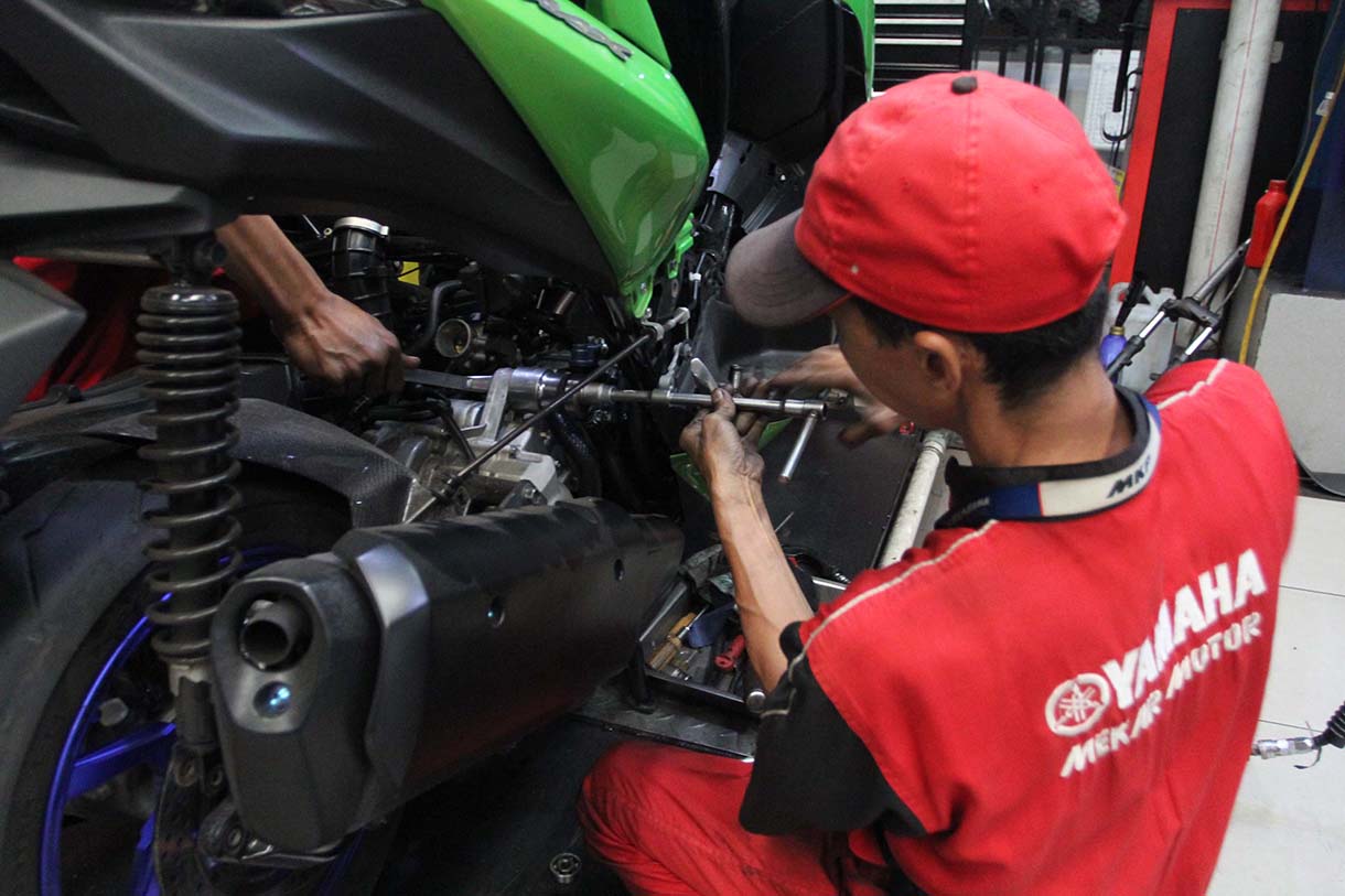 Mekanik memperbaiki motor di bengkel motor Yamaha, Bintaro, Jakarta, Rabu (19/3/2025).  (Beritanasional.com/Oke Atmaja)