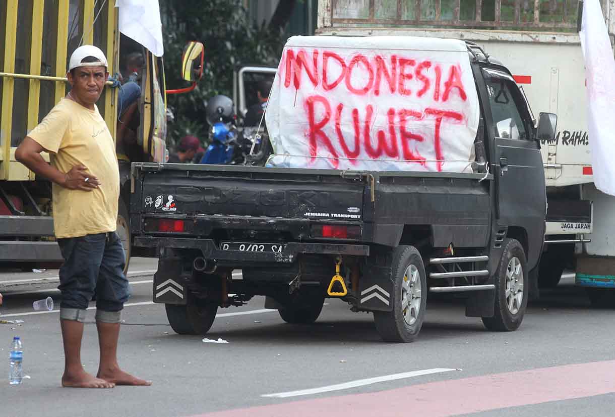 Seorang peserta aksi soal nol kelebihan muatan atau zero over dimensi over loading (ODOL) berorasi di Jalan Medan Merdeka Selatan, Jakarta, Rabu (2/7/2025). (Beritanasional.com/Oke Atmaja)