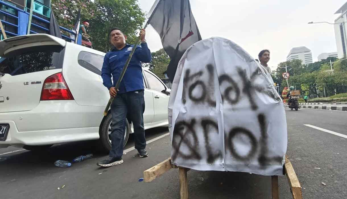 Seorang peserta aksi soal nol kelebihan muatan atau zero over dimensi over loading (ODOL) berorasi di Jalan Medan Merdeka Selatan, Jakarta, Rabu (2/7/2025). (Beritanasional.com/Oke Atmaja)