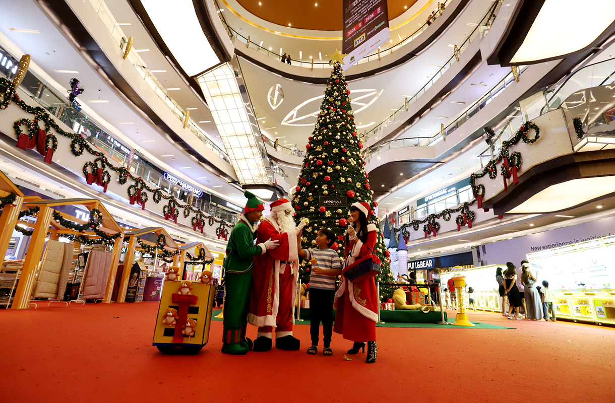 Pengunjung berfoto dengan latar pohon Natal di Lippo Mall Kemang, Jakarta, Selasa (24/12/2024). (BeritaNasional.com/Oke Atmaja)