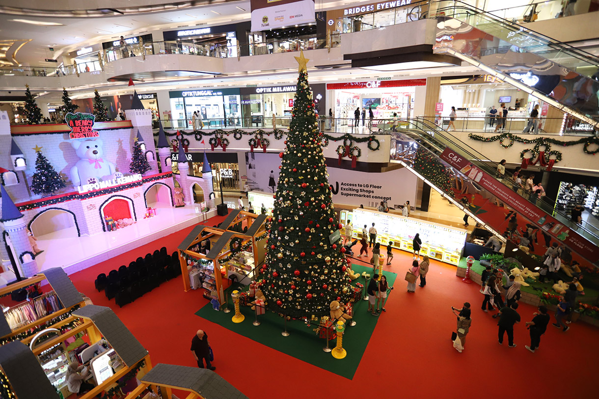 Pengunjung berfoto dengan latar pohon Natal di Lippo Mall Kemang, Jakarta, Selasa (24/12/2024). (BeritaNasional.com/Oke Atmaja)