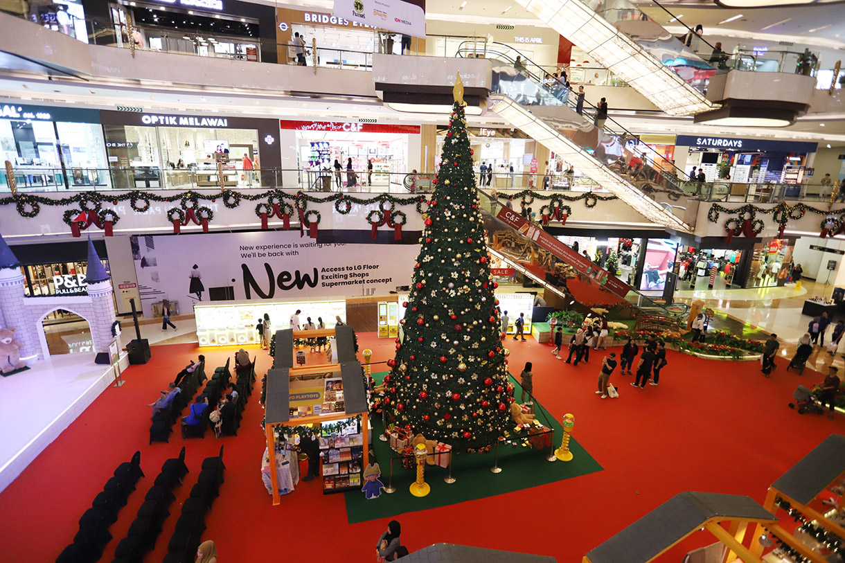 Pengunjung berfoto dengan latar pohon Natal di Lippo Mall Kemang, Jakarta, Selasa (24/12/2024). (BeritaNasional.com/Oke Atmaja)