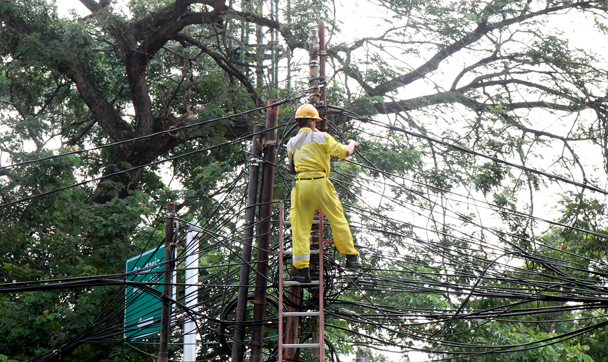 Petugas Sudin Bina Marga Jakarta Pusat memperbaiki kabel yang semerawut dan menjuntai di Kawasan Senayan,Selasa (23/7/2024). (BeritaNasional.com/Oke Atmaja)