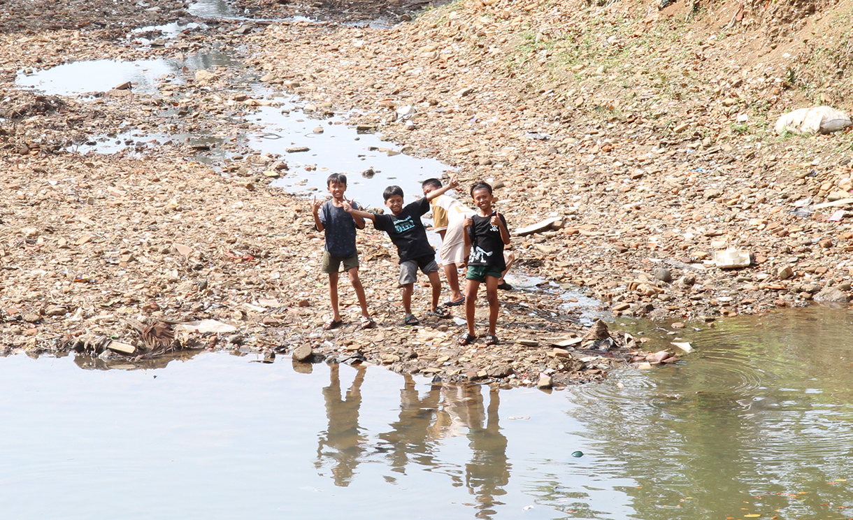 Anak anak bermain di Sungai Ciliwung yang mengering di kawasan Manggarai, Jakarta, Rabu (7/8/2024).  (BeritaNasional.com/Oke Atmaja)