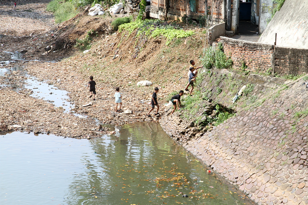 Anak anak bermain di Sungai Ciliwung yang mengering di kawasan Manggarai, Jakarta, Rabu (7/8/2024).  (BeritaNasional.com/Oke Atmaja)