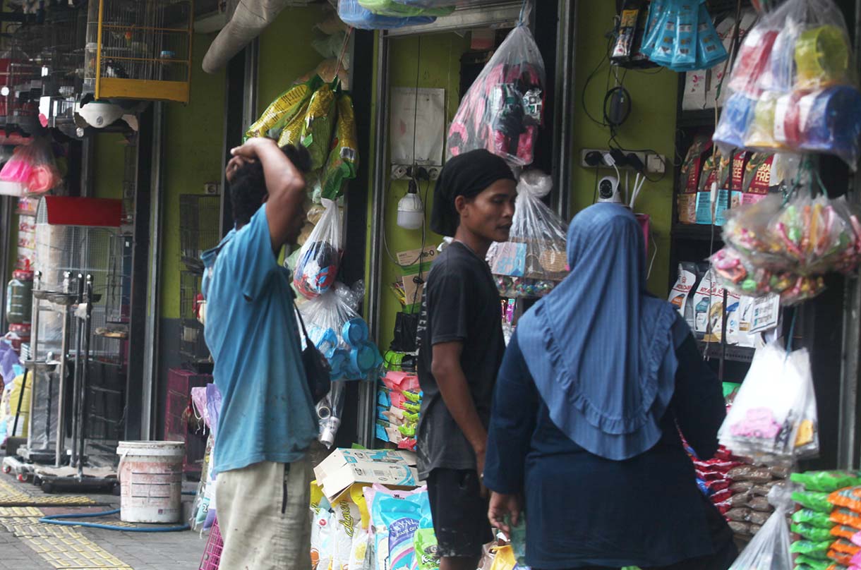 Pedagang membersihkan tempat makan burung pasar burung barito, kebayoran Baru, Jakarta, Jumat (10/10/2025). (Beritanasional.com/Oke Atmaja)