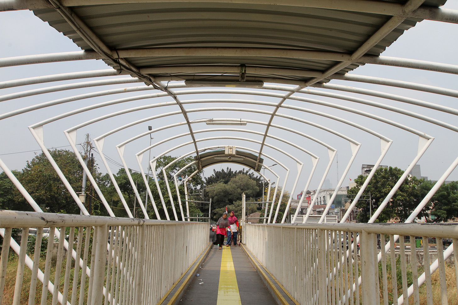 Pejalan kaki melintasi jembatan penyeberangan orang (JPO) Jayakarta di kawasan Menteng, Jakarta, Senin (15/4/2024). (BeritaNasional.Com/Oke Atmaja)