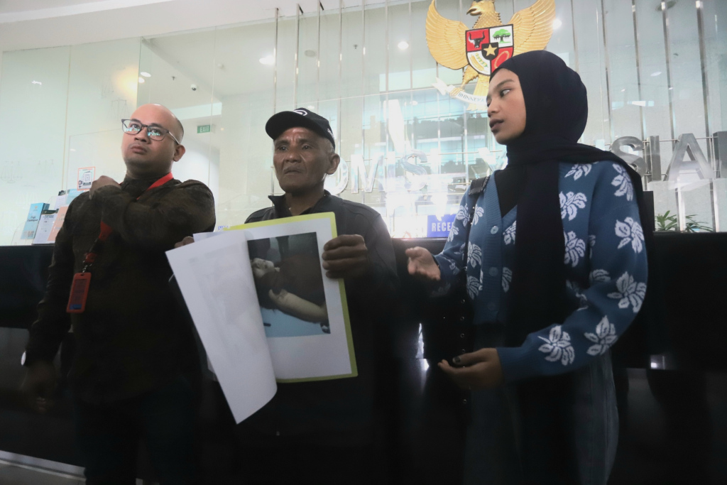 Ujang, ayah kandung dari alhmarhumah Dini bersama Alfika Risma adik Dini dan Kuasa Hukum keluarga Korban Dini Sera Afrianti, Dimas Yemahura Alfaraouq melapor ke kantor Komisi Yudisial, Jakarta, Senin (29/7/2024).  (BeritaNasional.com/OkeAtmaja)