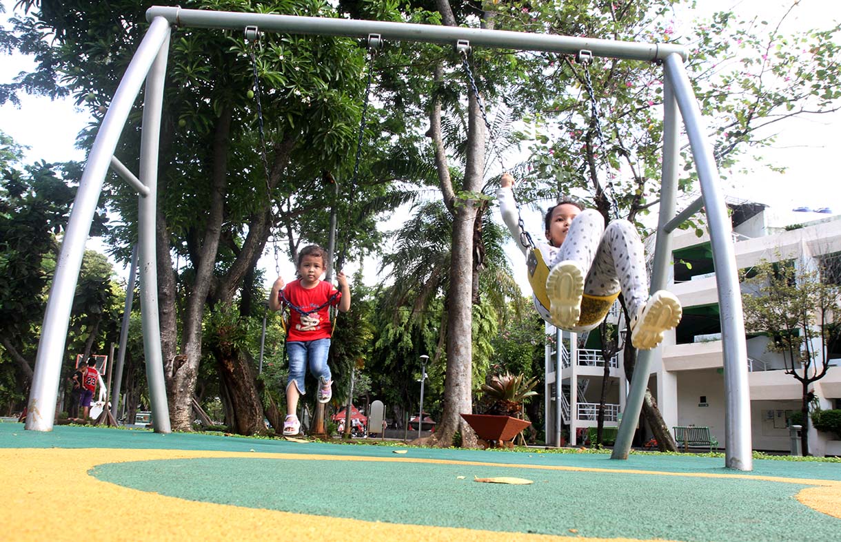 Anak anak bermain ayunan di Taman Menteng, Jakarta, Minggu (25/5/2025).(Beritanasional.com/Oke Atmaja)