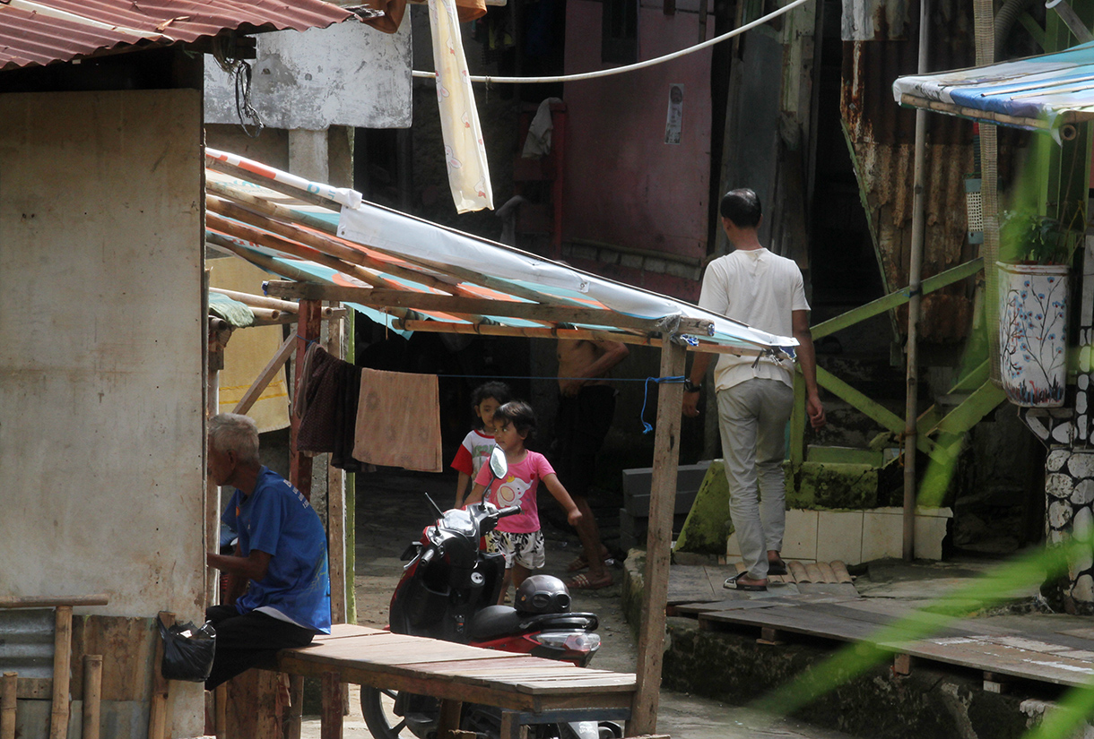 Warga berakfifitas di dekat kali ciliwung, Manggarai,Jakarta, Rabu (23/7/2025). (Beritanasional.com/Oke Atmaja)