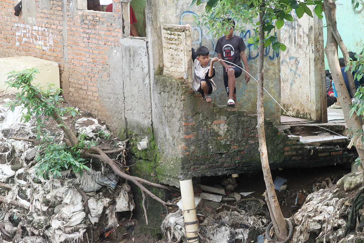 Warga berakfifitas di dekat kali ciliwung, Manggarai,Jakarta, Rabu (23/7/2025). (Beritanasional.com/Oke Atmaja)