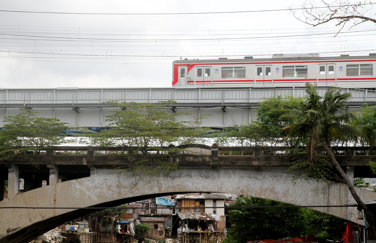 Warga berakfifitas di dekat kali ciliwung, Manggarai,Jakarta, Rabu (23/7/2025). (Beritanasional.com/Oke Atmaja)
