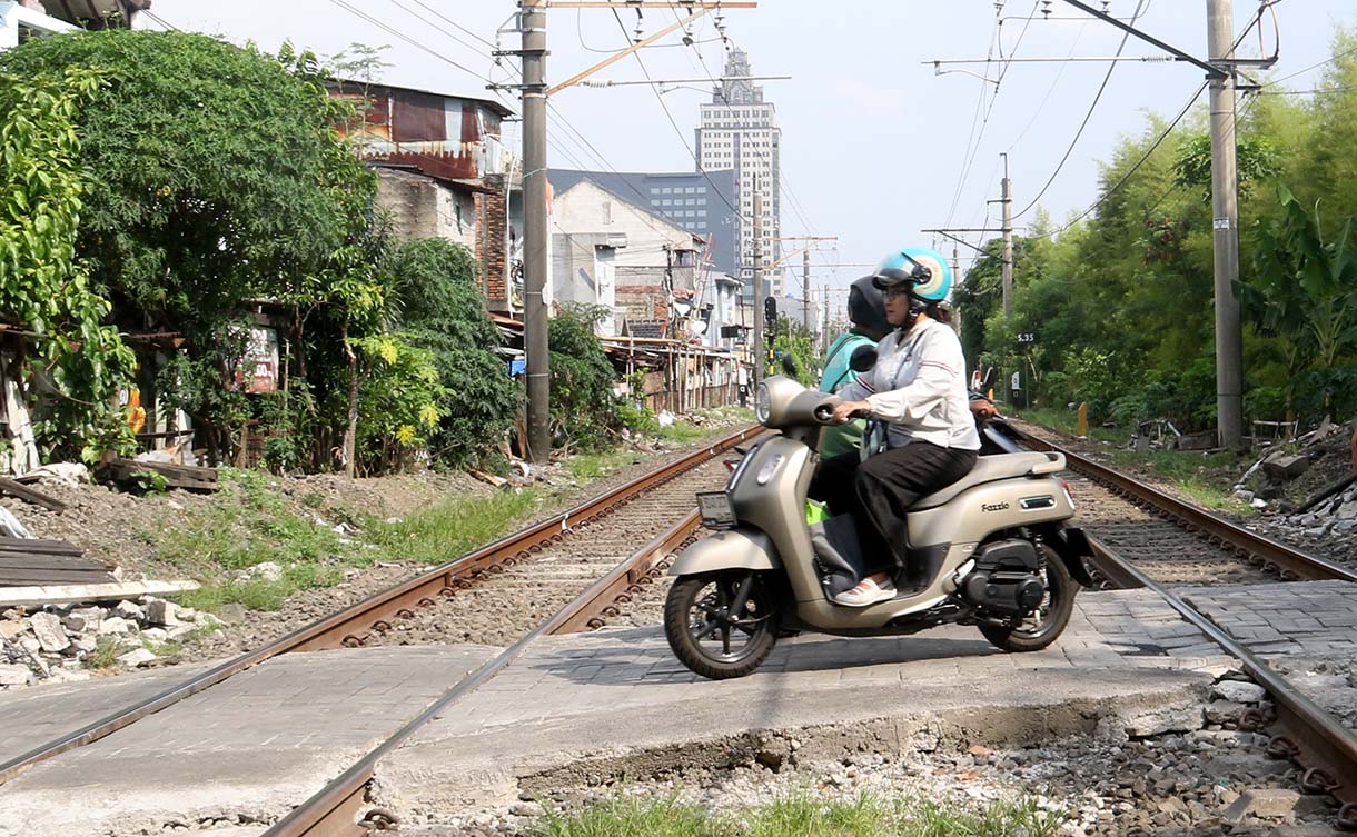 Pengendara motor melewati perlintasan kereta api sebidang di kawasan Pejagalan, Penjaringan, Jakarta, Jumat (19/6/2026).  (Beritanasional.com/Oke Atmaja)