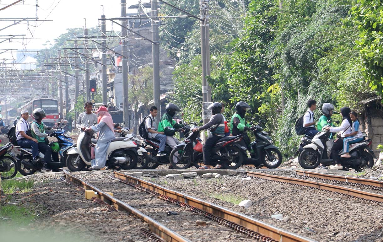 Pengendara motor melewati perlintasan kereta api sebidang di kawasan Pejagalan, Penjaringan, Jakarta, Jumat (19/6/2026).  (Beritanasional.com/Oke Atmaja)