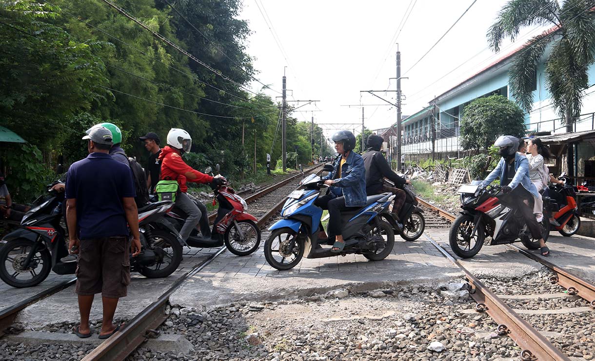 Pengendara motor melewati perlintasan kereta api sebidang di kawasan Pejagalan, Penjaringan, Jakarta, Jumat (19/6/2026).  (Beritanasional.com/Oke Atmaja)