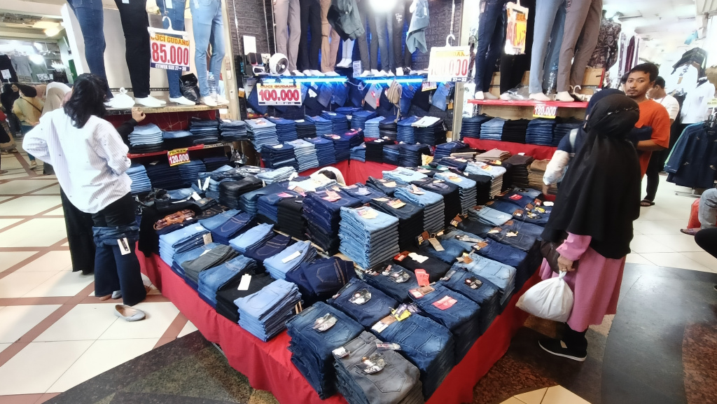 Target Pertumbuhan Ekonomi Indonesia Pengunjung memilih pakaian di pasar Tanah Abang, Jakarta, Selasa (13/5/2025). (Beritanasional.com/Oke Atmaja)