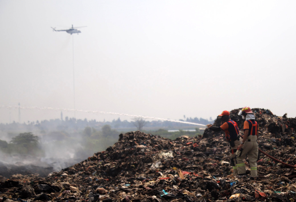 Petugas pemadam kebakaran berusaha memadamkan api di Tempat Pembuangan Akhir (TPA) Jatiwaringin, Kabupaten Tangerang, Banten, Senin (6/7/2026). (Beritanasional.com/Oke Atmaja)